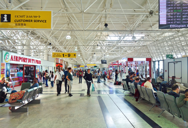 Interior of Addis Ababa Bole International Airport (ADD) with duty-free shops and passenger services.
