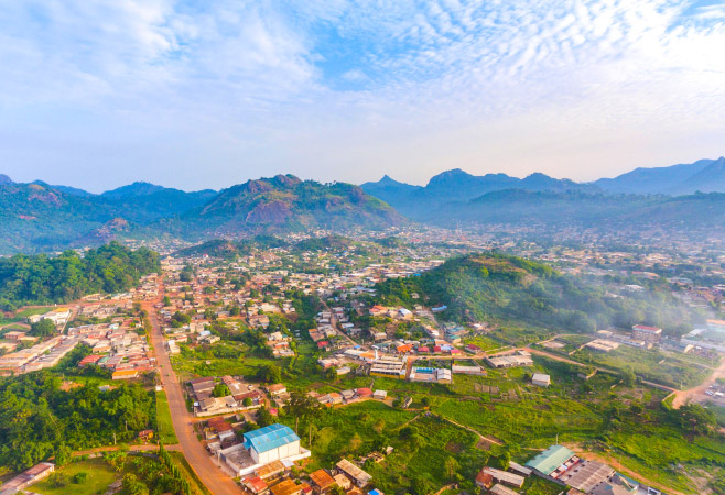Man is surrounded by misty mountains, waterfalls, and coffee plantations